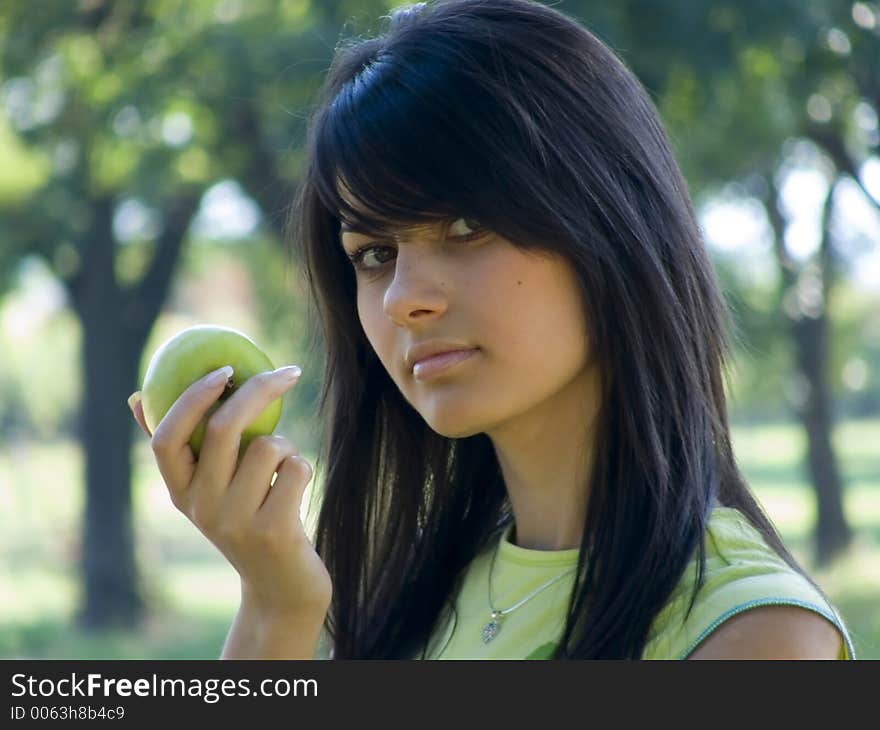 Beautiful young woman holding green apple in hand. Beautiful young woman holding green apple in hand