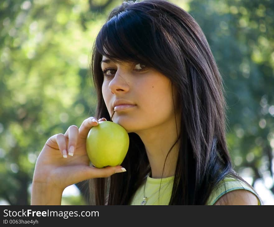 Beautiful young woman holding green apple in hand. Beautiful young woman holding green apple in hand