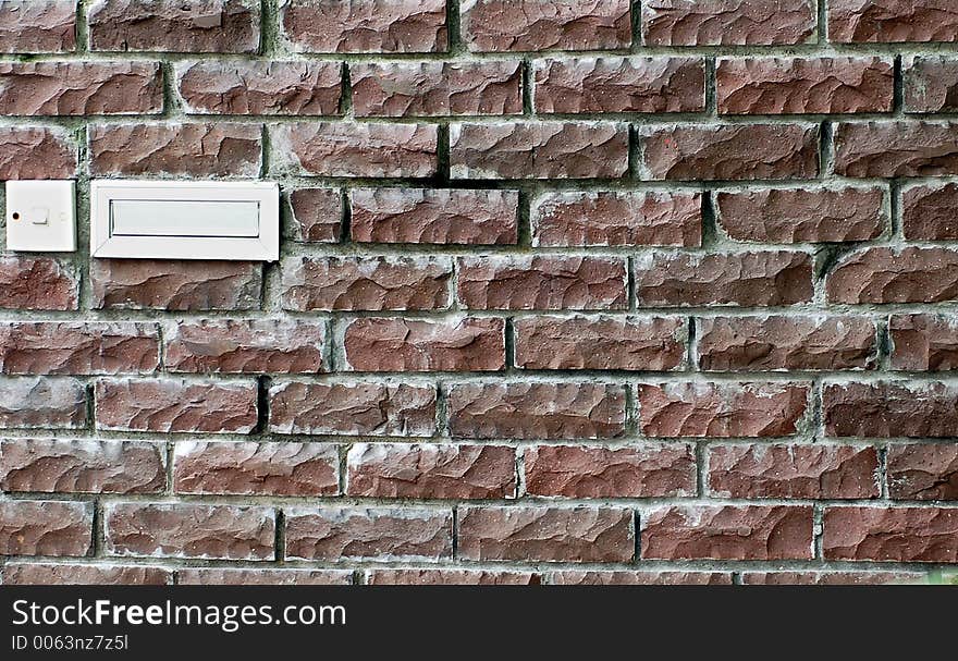 Brick wall with post box and door bell switch