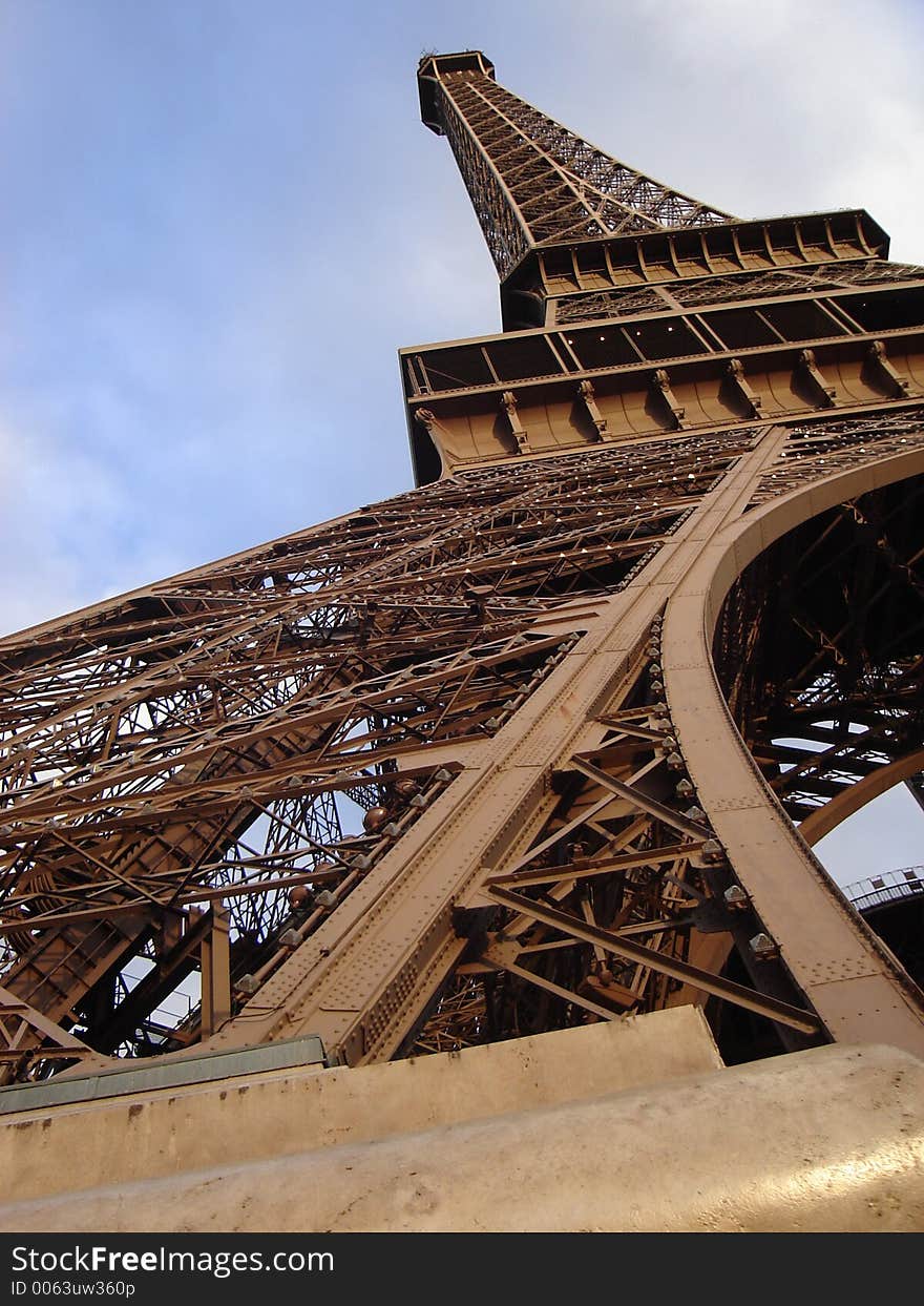 A shot of the Eiffel Tower at daytime from the bottom of one base to the top. A shot of the Eiffel Tower at daytime from the bottom of one base to the top.