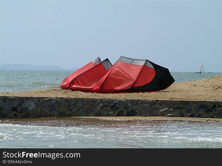 Red kite-surfer kite left on the beach. Red kite-surfer kite left on the beach