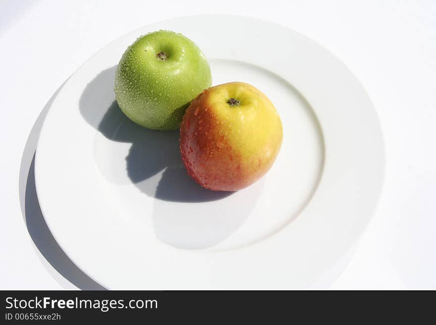 Two apples on a white plate. Two apples on a white plate