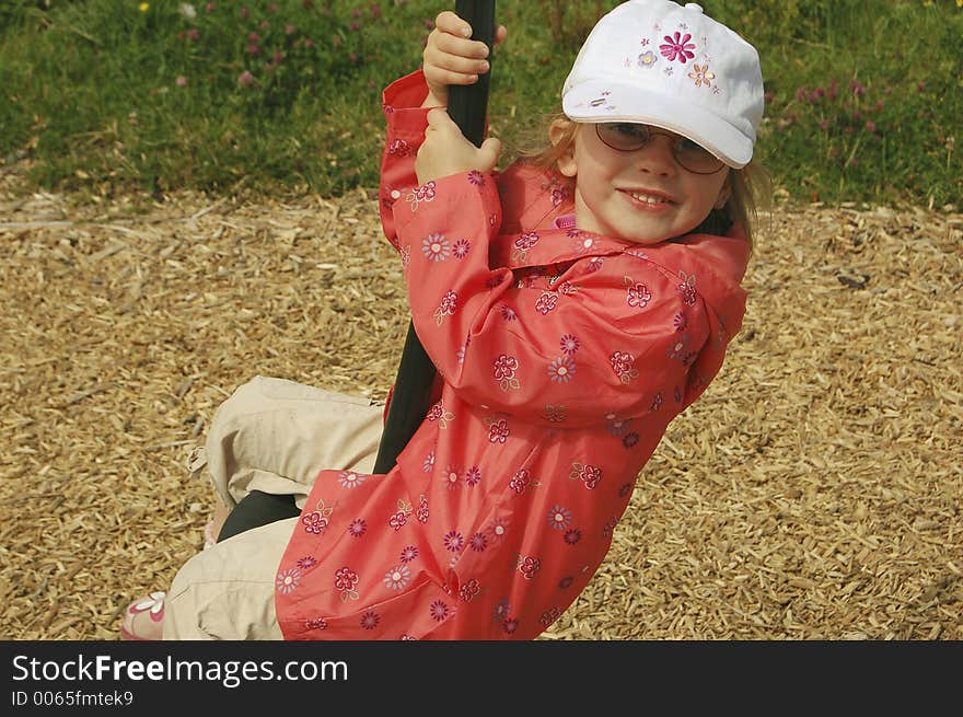 Child swinging from a playground frame.