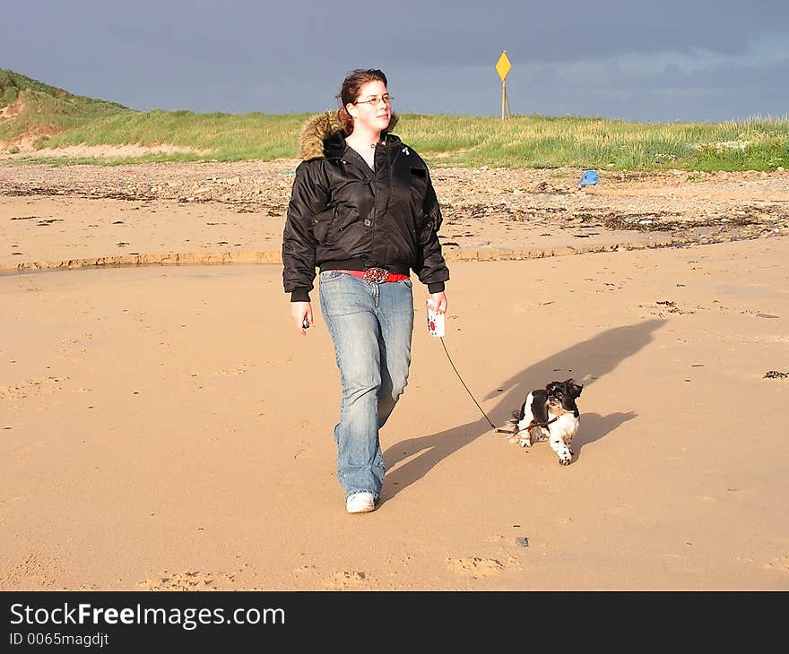 A young teenager walking a dog. A young teenager walking a dog.