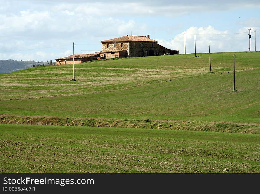 House and electric poles in agriculture landscape in Tuscany, Italy. House and electric poles in agriculture landscape in Tuscany, Italy.