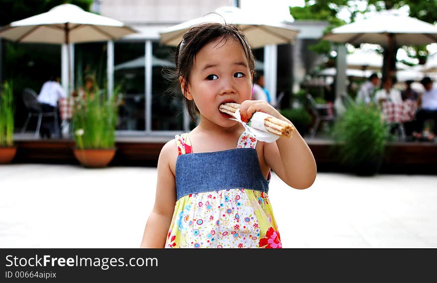 Pretty Korean girl takes a bite to eat. Pretty Korean girl takes a bite to eat