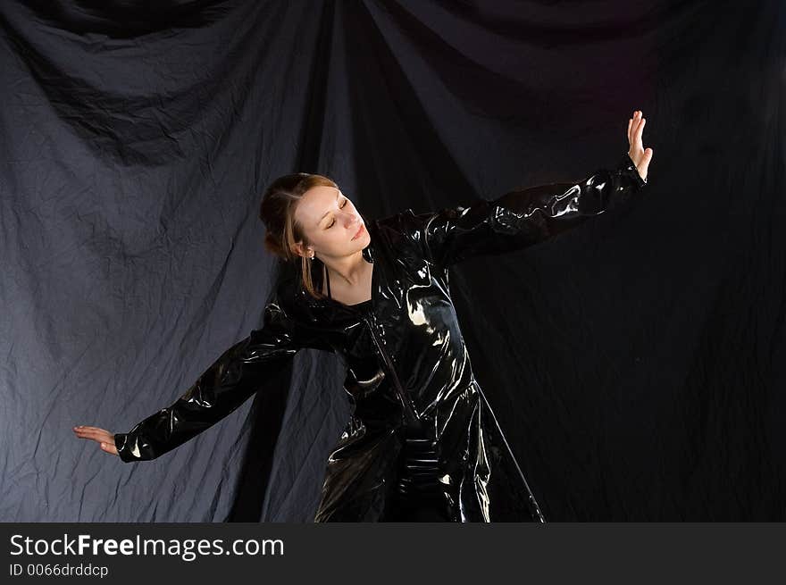 A dancer posed in a jazz pose, costumed in black vinyl. A dancer posed in a jazz pose, costumed in black vinyl