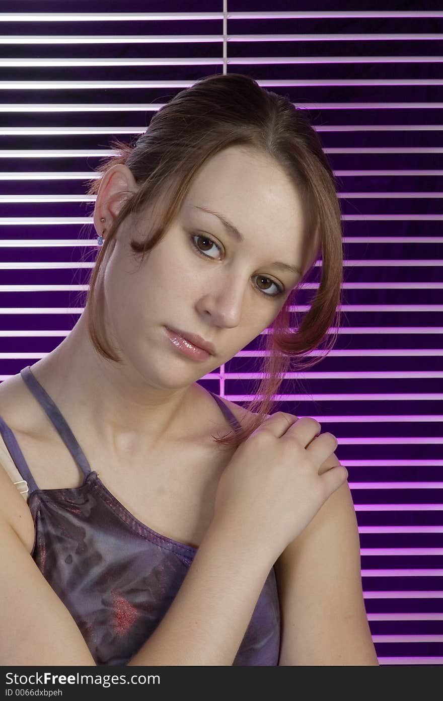 A serious portrait of a young woman woth verticle blind and a splash of purple in the background. A serious portrait of a young woman woth verticle blind and a splash of purple in the background