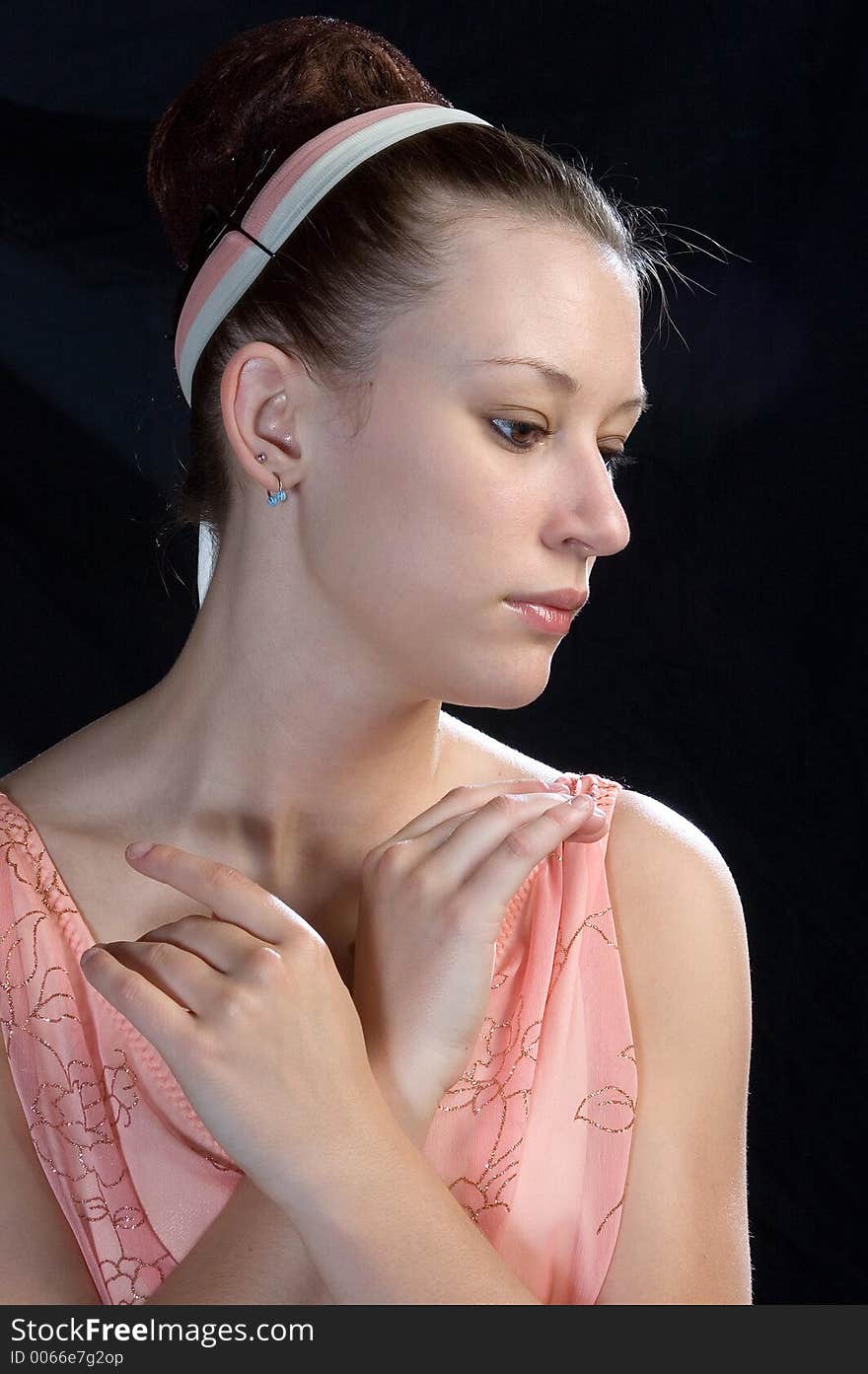 A close up view of a ballerina with hands posed at neck-line. A close up view of a ballerina with hands posed at neck-line