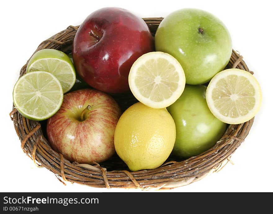 Large selection of colorful fruit including apples, lemons, and limes in a basket isolated on a white background.  Viewed from above. Large selection of colorful fruit including apples, lemons, and limes in a basket isolated on a white background.  Viewed from above.