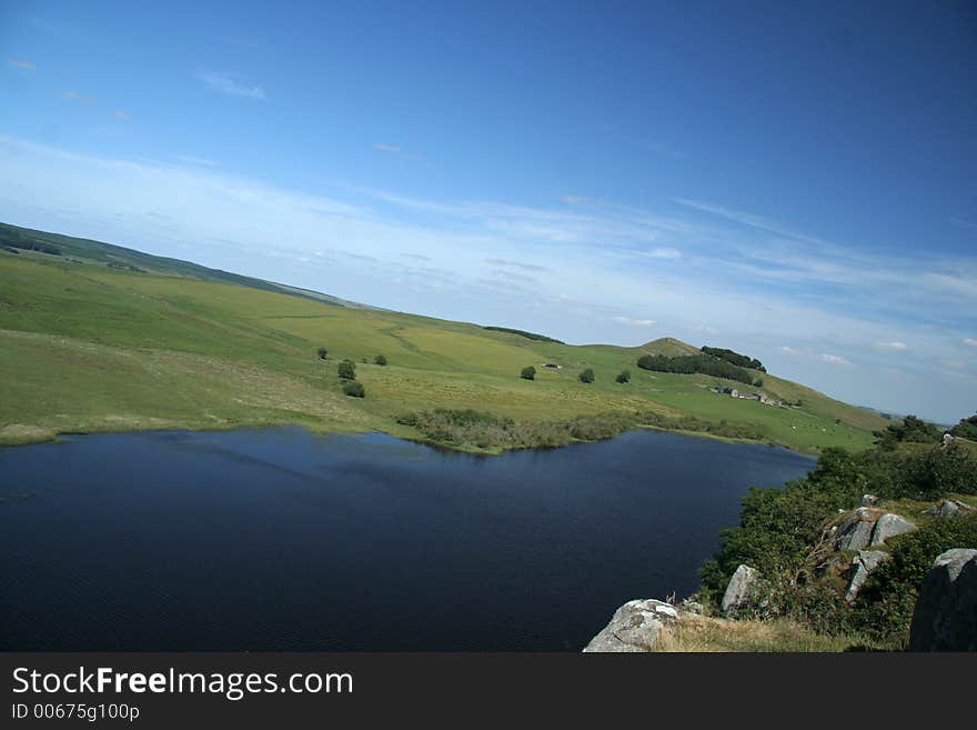 Beautiful Northumbrian Farm steading  nesled into the hillside with a lough at the field infront of it. Beautiful Northumbrian Farm steading  nesled into the hillside with a lough at the field infront of it