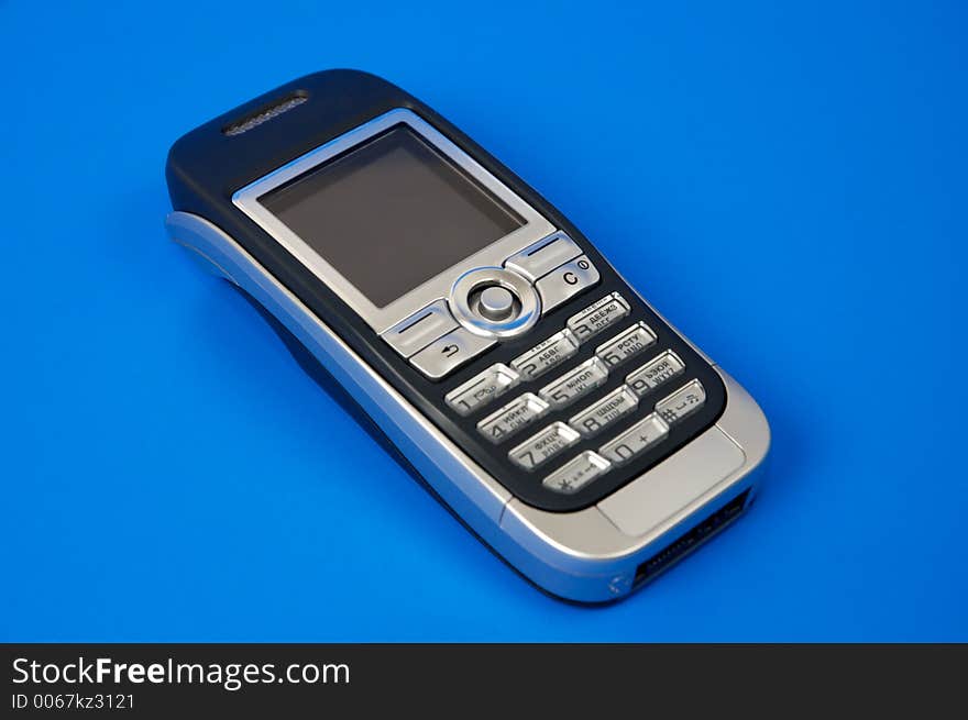 Gray modern cellphone isolated on blue background close-up