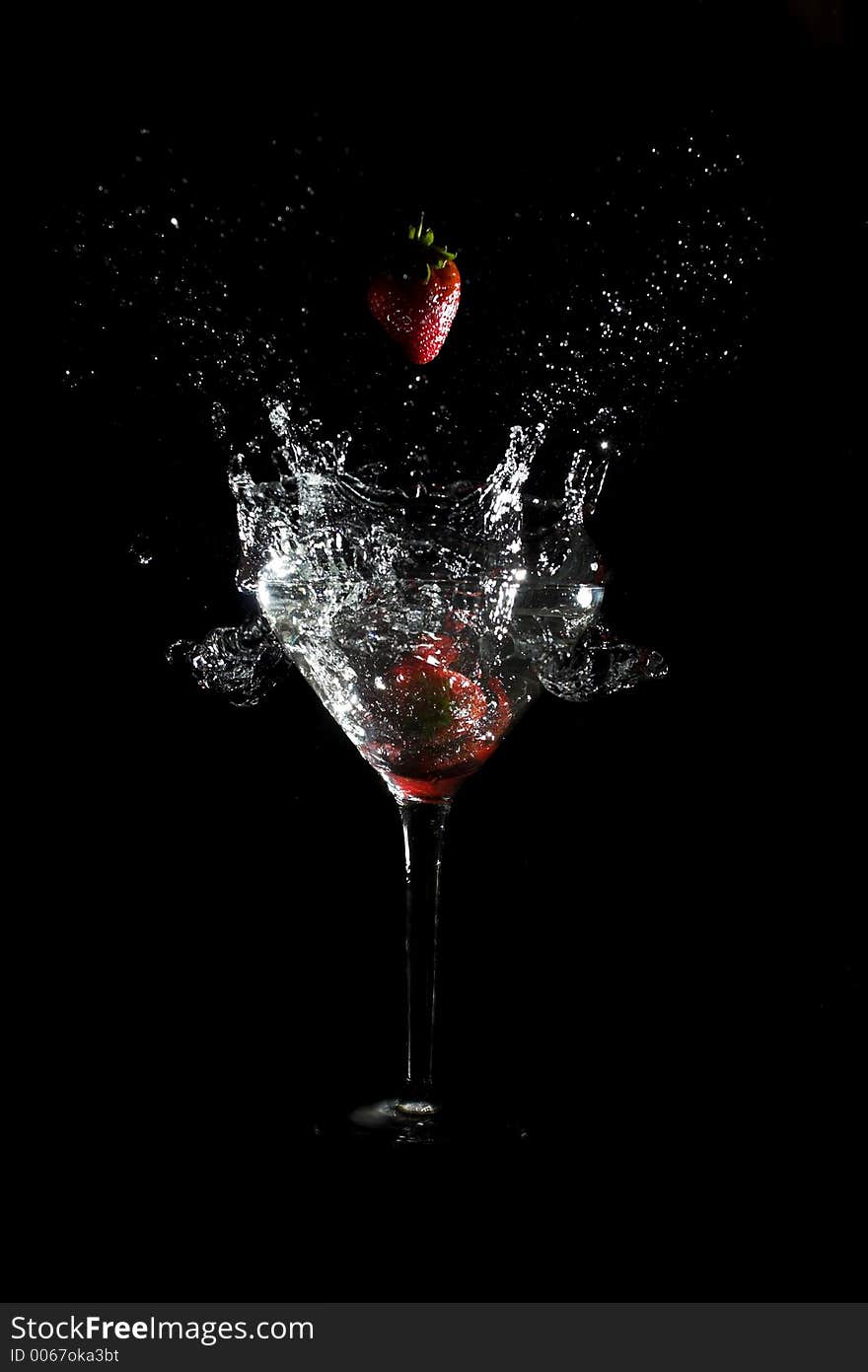 Strawberry falling into glass of water. Strawberry falling into glass of water