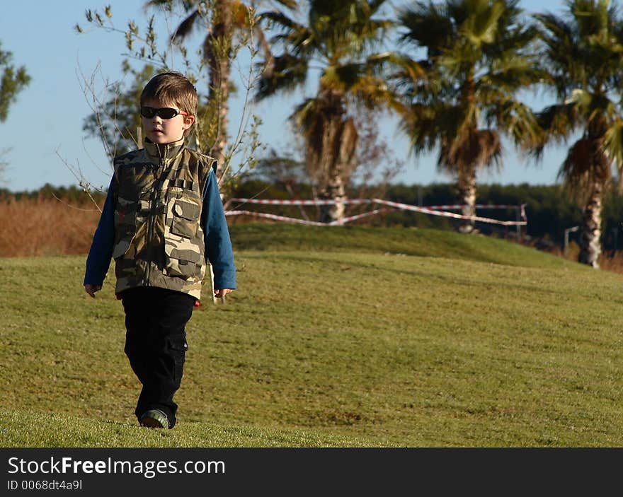 Young boy with sunglasses and camouflage jacket