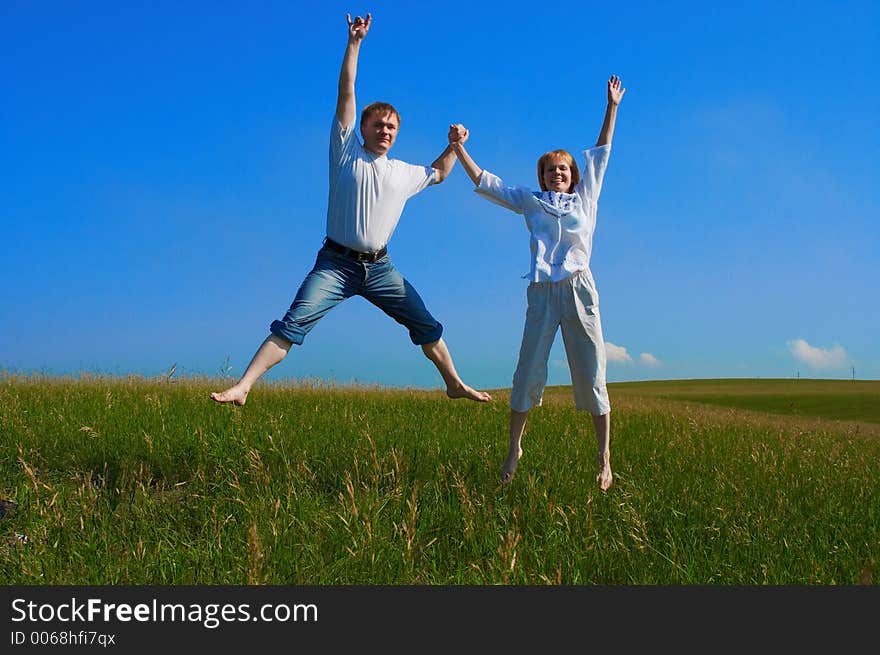 Couple Jumping In Field