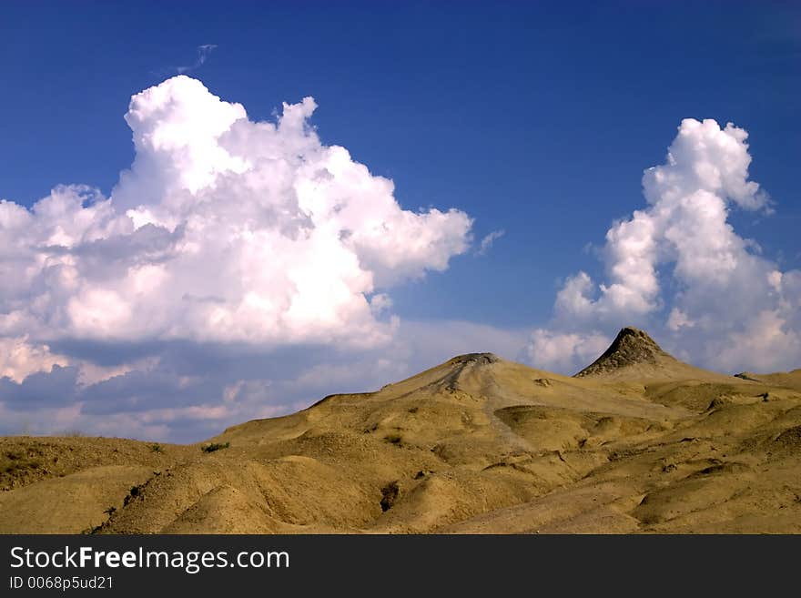 Mud volcanoes with spectaculous clouds from Mud Volcanoes - Buzau, Romania (unique geological phenomenon in Europe where the earth gas reaches the surface through hills making small Mud volcanoes)