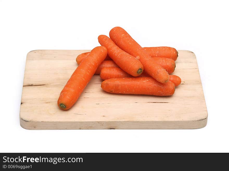 Carrots arranged on a wooden chopping board