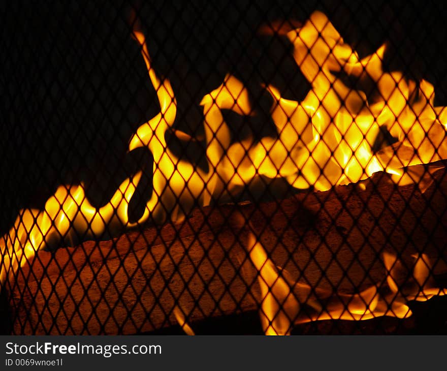 Closeup of Outdoor Firepit - flames and wood behind a grate