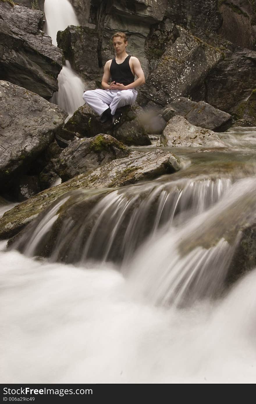 Man meditating on a stream with his katana on laps after practicing fencing skills. Man meditating on a stream with his katana on laps after practicing fencing skills