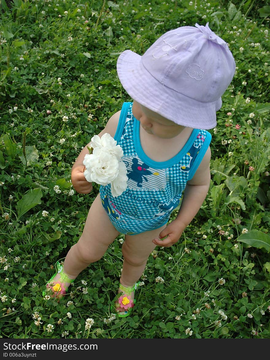 Little girl in lilac hat with white flower