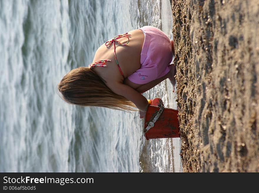 Little girl is playing with sand at beach. Little girl is playing with sand at beach