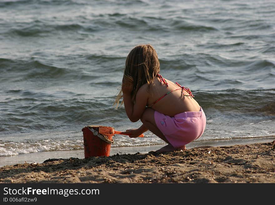 Little girl is playing with sand at beach. Little girl is playing with sand at beach