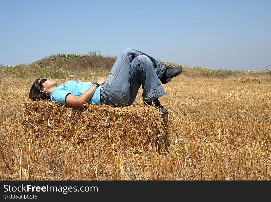 Girl laying down in a stack of hay. Girl laying down in a stack of hay