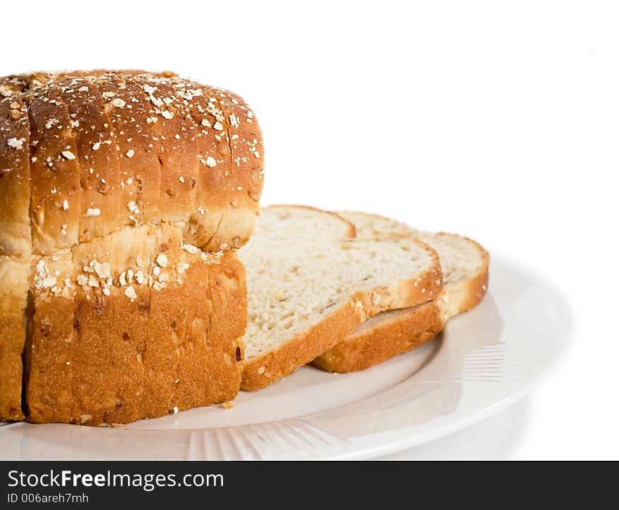 Loaf of sliced bread on plate. Isolated on white.