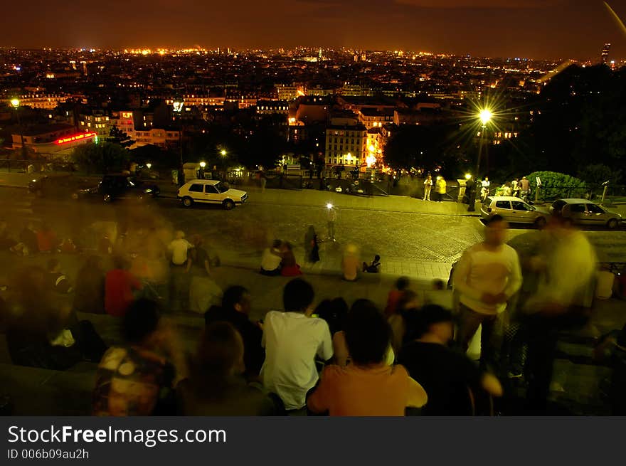 Late night in Paris - a view from stairs at Basilica Sacre Ceur, Monmartre, people admiring view, long exposition,. Late night in Paris - a view from stairs at Basilica Sacre Ceur, Monmartre, people admiring view, long exposition,