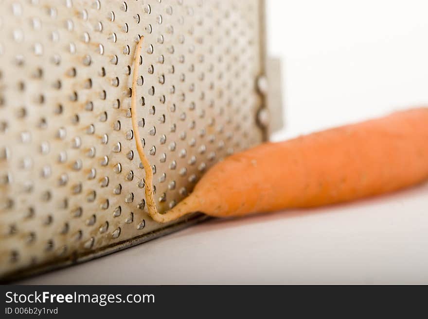 Carrots near the old grater. Carrots near the old grater