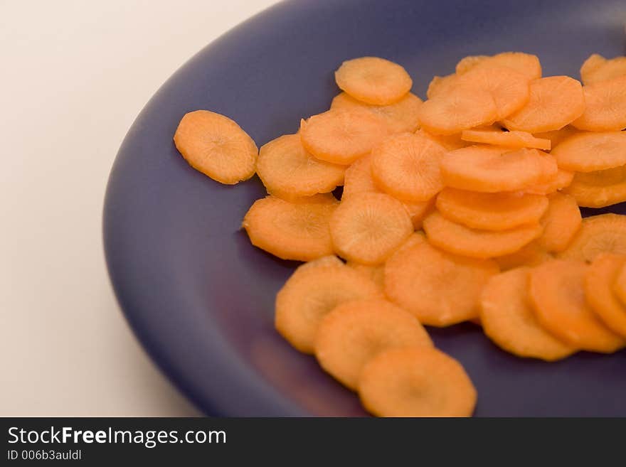 Carrot, sliced by circles on a blue plate