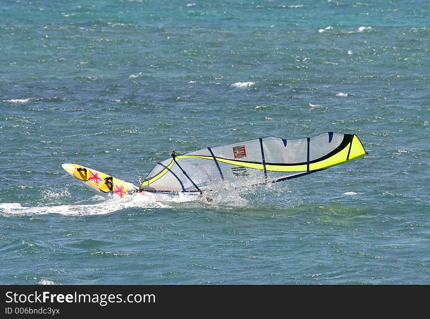 A windsurfer capsizes at speed