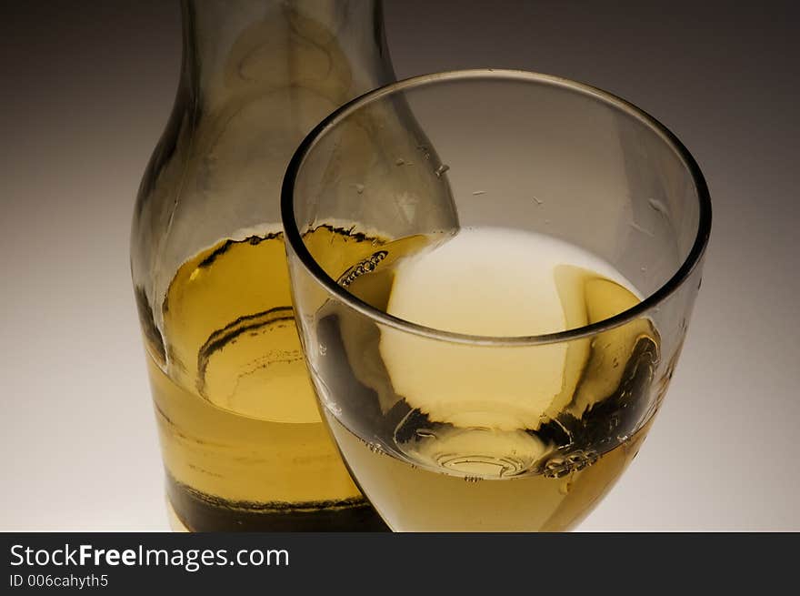 Glass of white wine and bottle