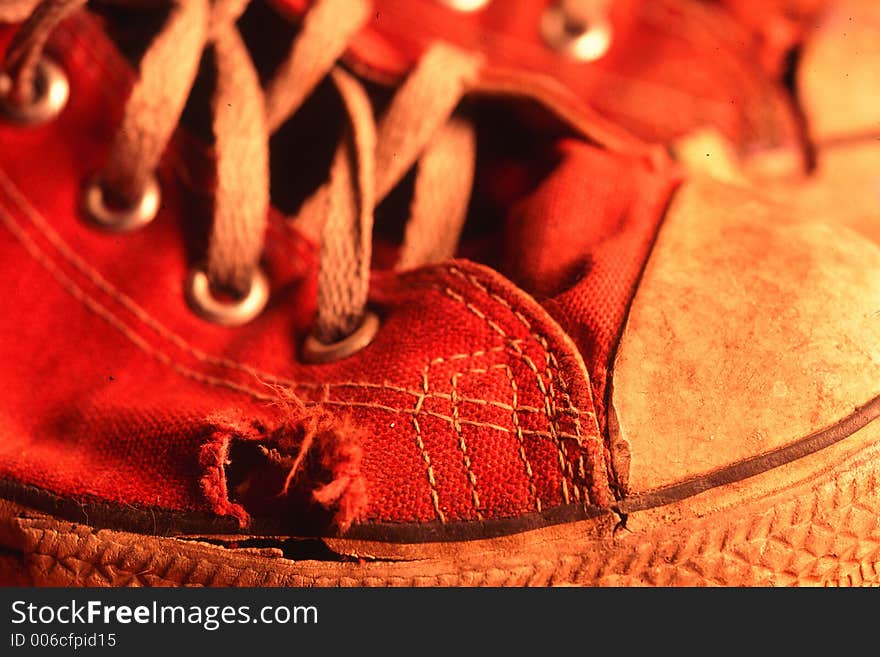 Red tennis shoe with worn through toe area