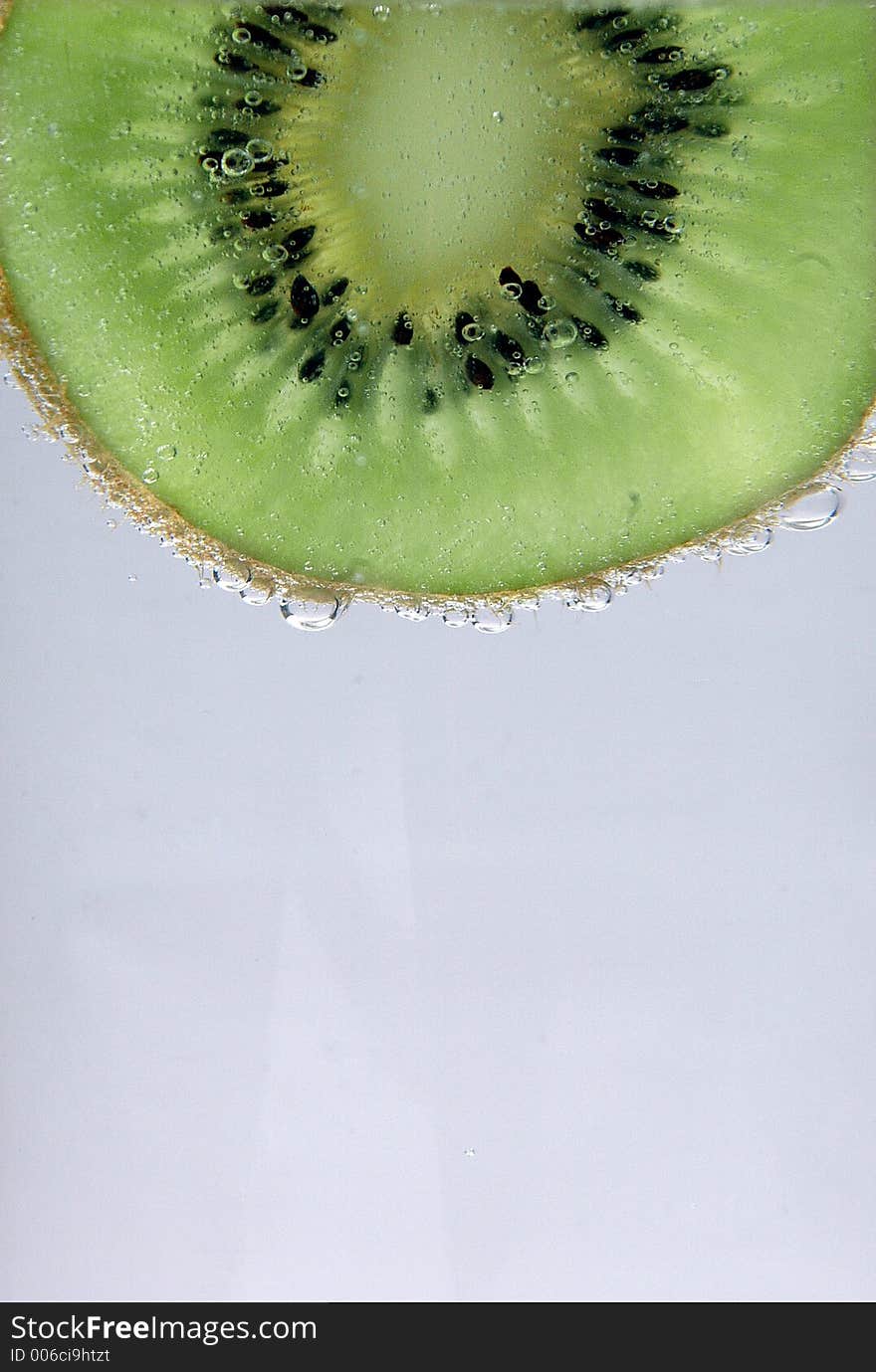 Slice of kiwi dripping with water. Slice of kiwi dripping with water.