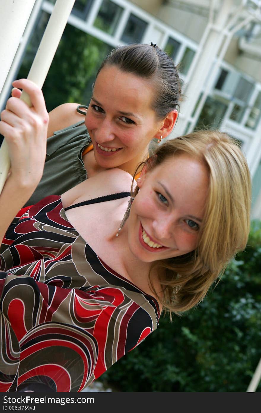 Two female friends smiling and posing on the street. Two female friends smiling and posing on the street