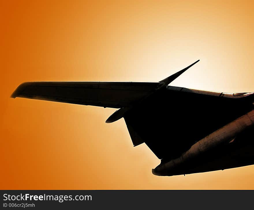 Silhouette of passenger airplane in the air against the sun