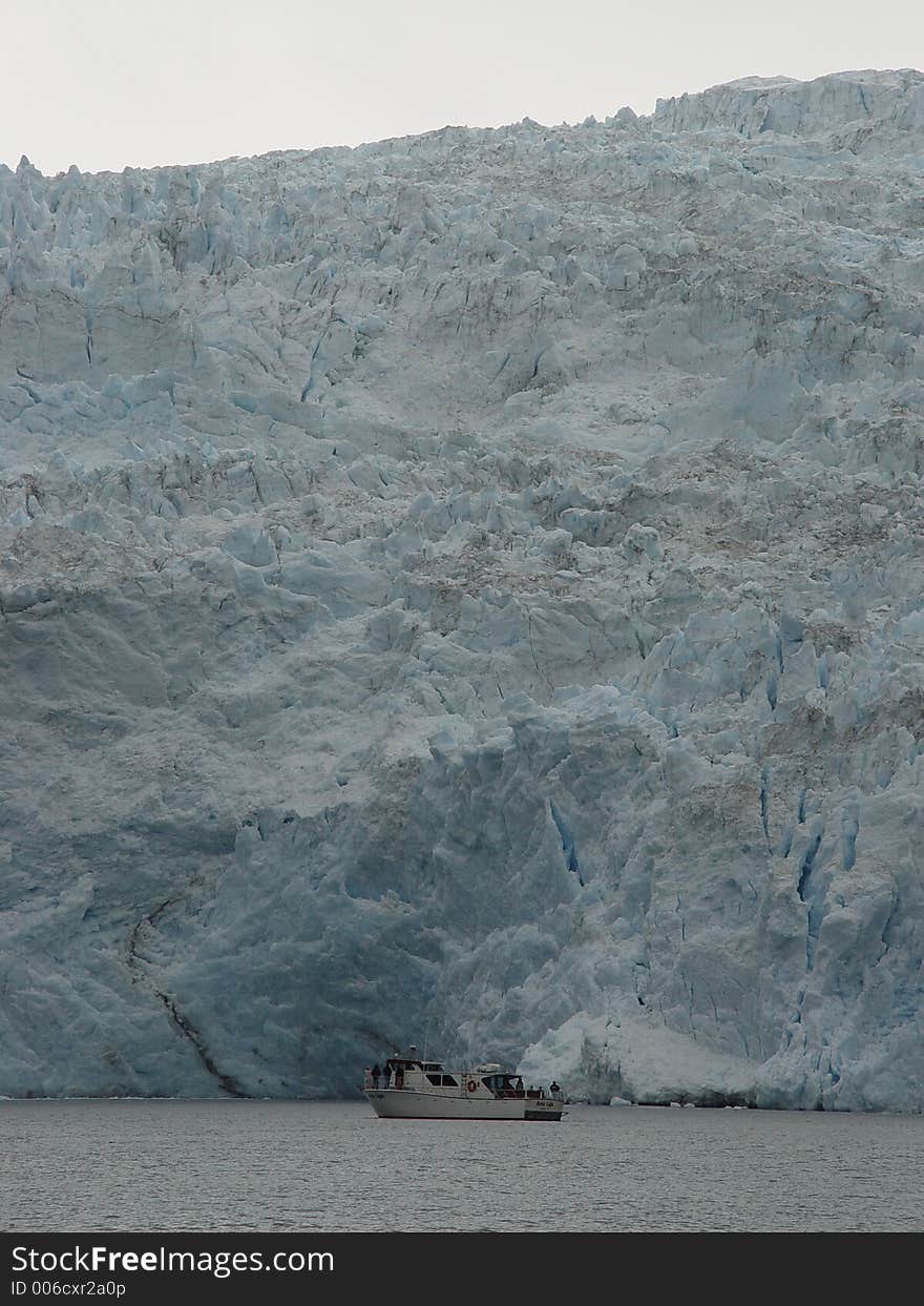 Small tourist boat at the foot of a glacier in Alaska. Small tourist boat at the foot of a glacier in Alaska.