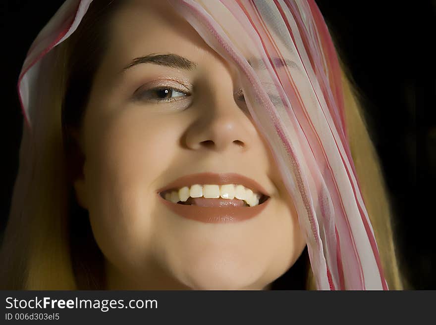 A young lady enjoys playing with a colorful scarf. A young lady enjoys playing with a colorful scarf.