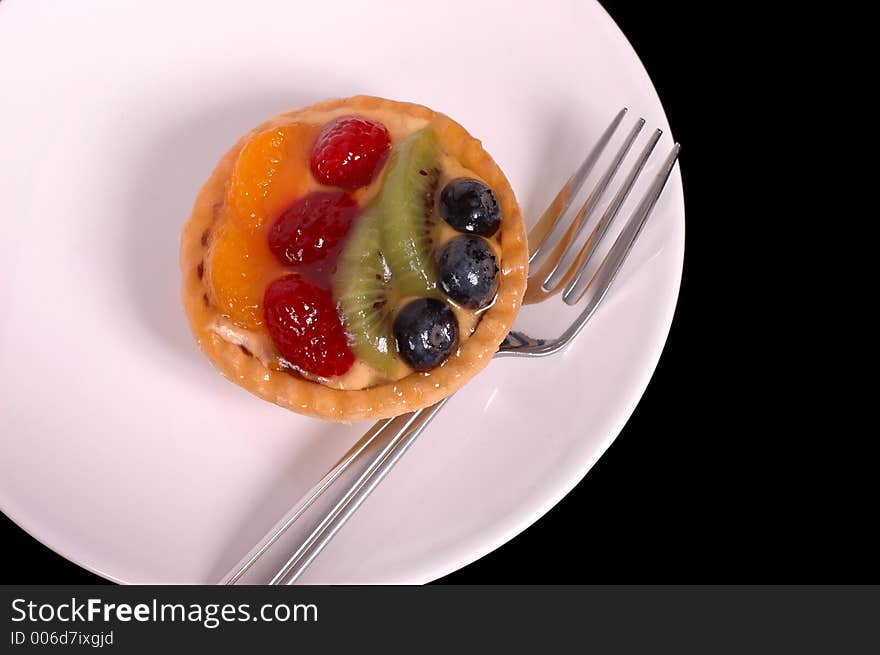 Fruit tart on white plate with fork. Fruit tart on white plate with fork