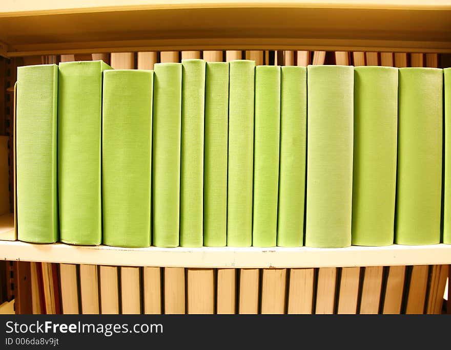 Row of colorful green books with no titles