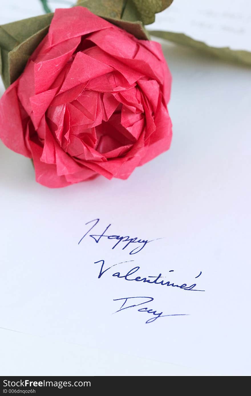 Origami rose on a piece of paper with a handwritten message. Origami rose on a piece of paper with a handwritten message