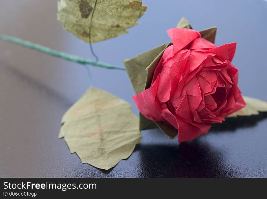 Origami rose on black table