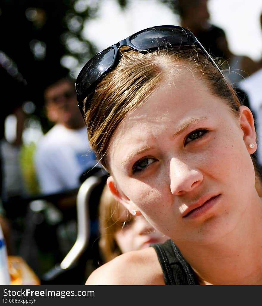 Teenage personalities showing through with a girl watching a parade without any excitement. Teenage personalities showing through with a girl watching a parade without any excitement