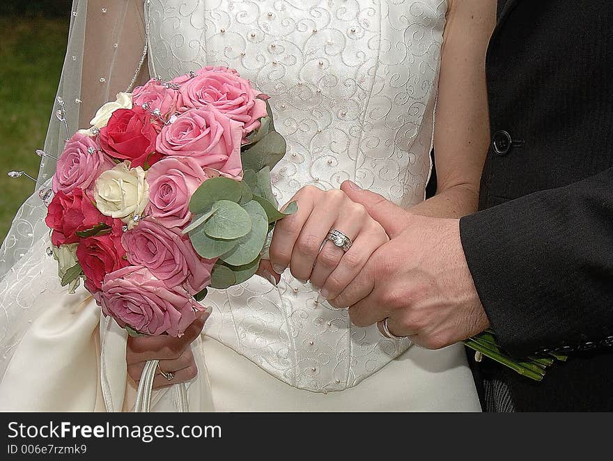 Bride holding bouquet and showing off wedding ring. Bride holding bouquet and showing off wedding ring