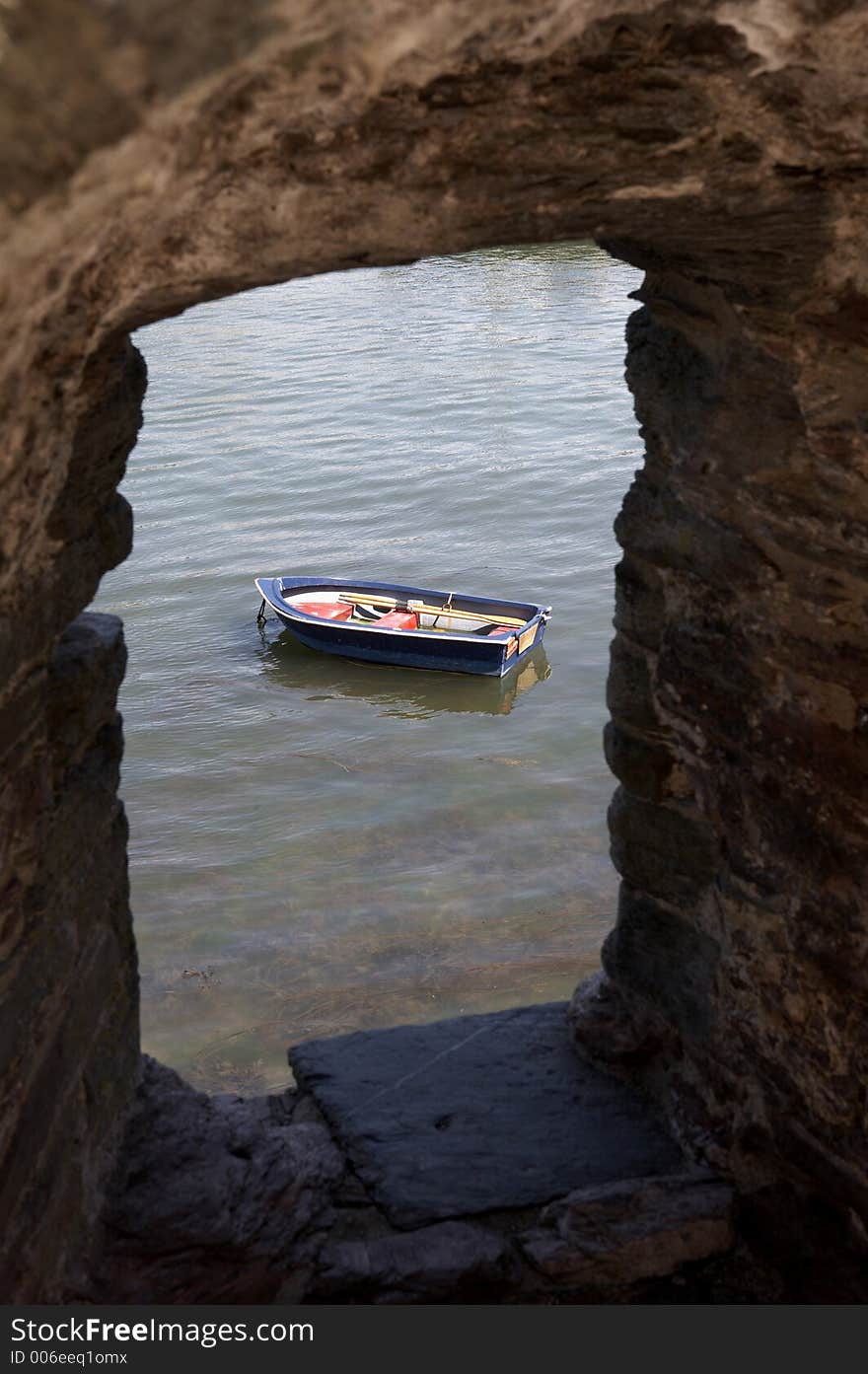 View of a small wooden row boat on the river dart looking through a stone walls window of bayards cove fort dartmouth devon england europe uk taken in july 2006