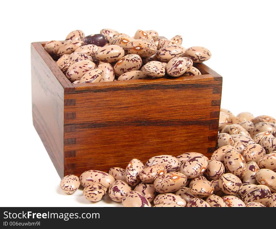 Spotted beans and a wooden cup, isolated over white background. Spotted beans and a wooden cup, isolated over white background.