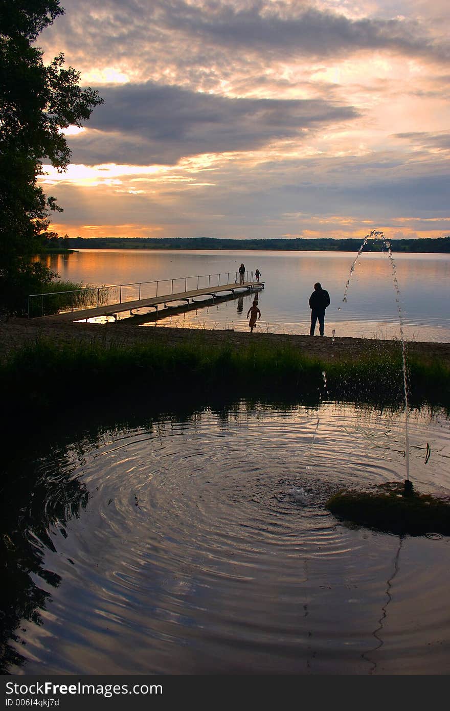 A lake in denmark , a so called bath bridge on a danish lake at the sunset