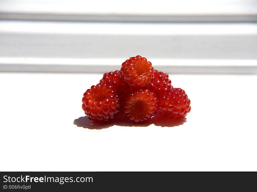 Fresh raspberries against the windowsill. Fresh raspberries against the windowsill.