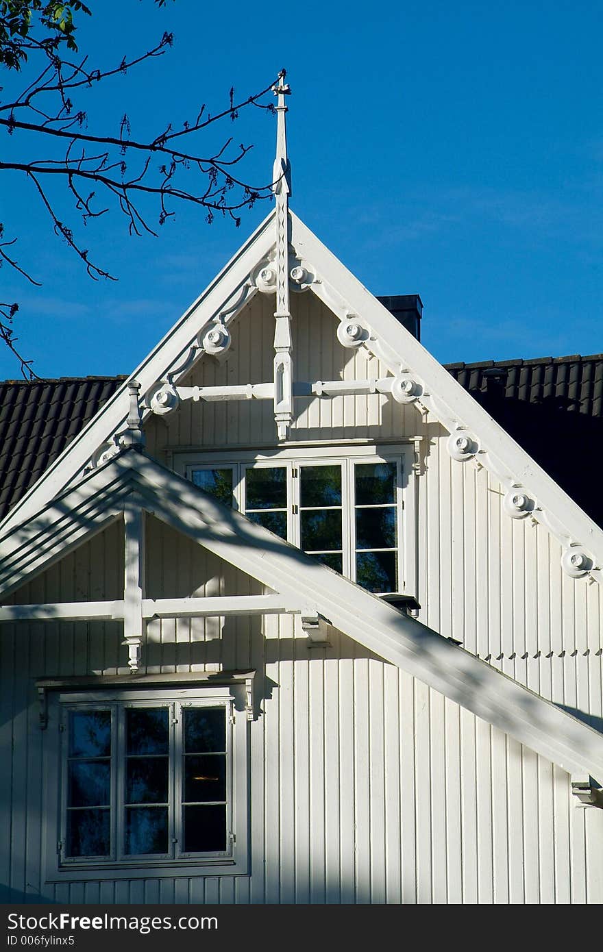 Detail of roof and windows of classic, white, wooden house. Detail of roof and windows of classic, white, wooden house.